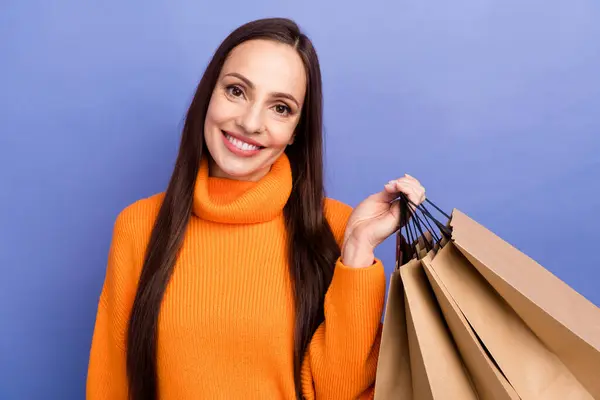 幸せな笑顔の成熟した女性の写真は 週末にショッピングでお金を費やすのが大好きです バイオレット色の背景に隔離された紙パッケージを持って来ます — ストック写真