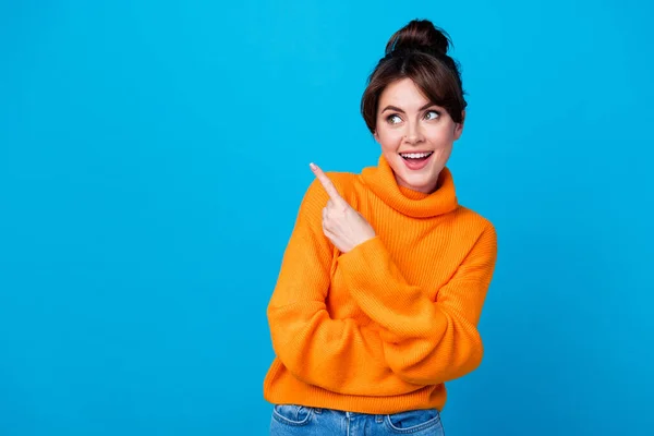 Photo of dreamy excited lady wear knitted pullover pointing finger looking empty space isolated blue color background.