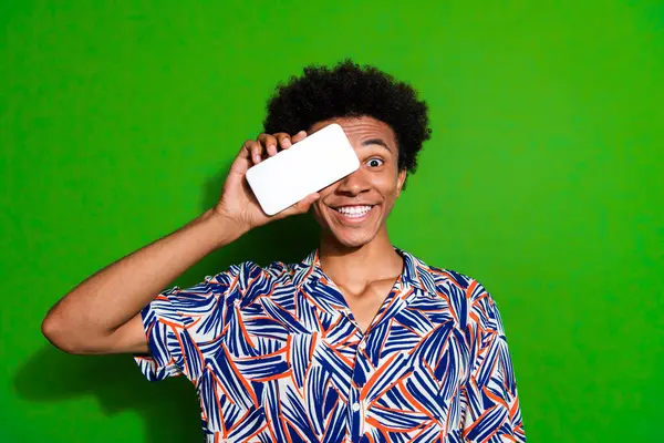 Photo of shy funky man dressed print shirt modern gadget close eye empty space isolated green color background.