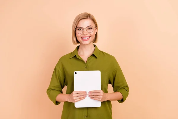 ボブヘアスタイルの豪華なスマートな女性の写真 緑のシャツはベージュ色の背景に隔離された会議で手でタブレットを保持 — ストック写真