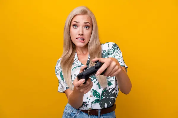 長い髪のドレスのシャツを持つ焦点を当てた愛らしい女の子の写真は 黄色の背景で隔離されたジョイスティックな遊び困難なビデオゲームを保持します — ストック写真