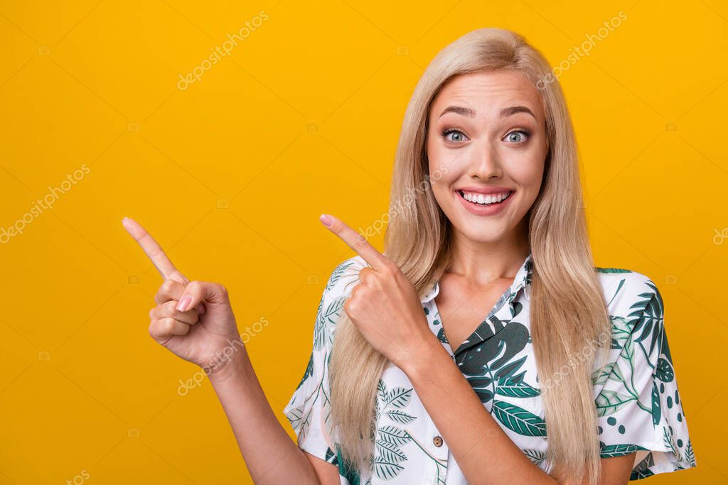 Portrait of ecstatic girl wear flower print blouse indicating at impressive discount empty space isolated on yellow color background.