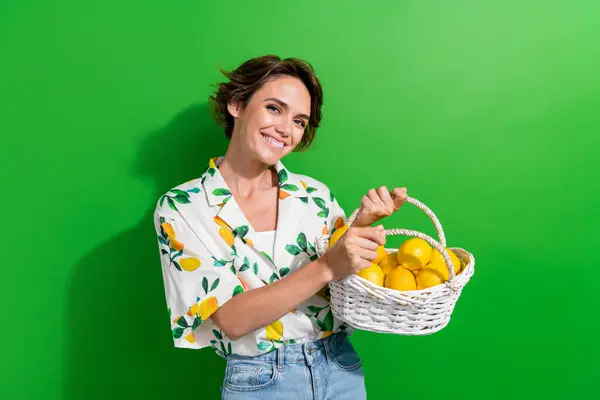 肯定的な若い魅力的な女性の茶色のボブの毛の写真は緑色の背景で隔離された新しい黄色いレモンの食料品店を持って来ます — ストック写真