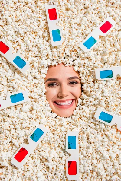 Above top view vertical portrait of positive pretty girl beaming smile good mood 3d glasses face stick through popcorn background.