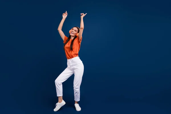 全长照片积极的心情女人穿着橙色T恤耳机跳舞迪斯科舞厅空旷的空间孤立的深蓝色背景 — 图库照片