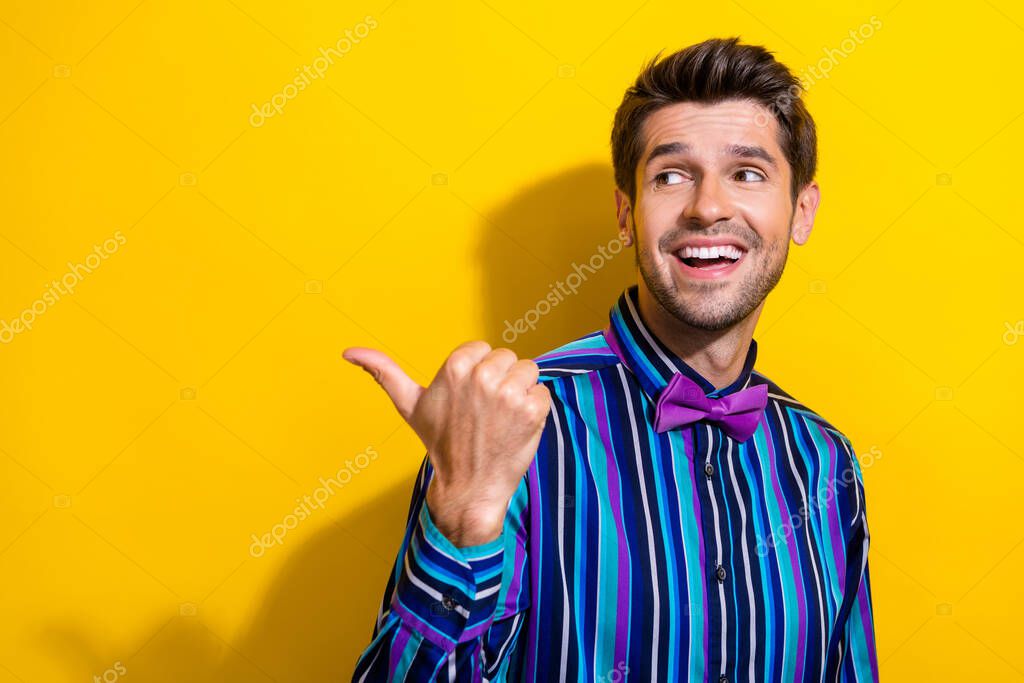 Photo of impressed astonished man dressed striped shirt look directing at discount empty space isolated on vivid yellow color background.