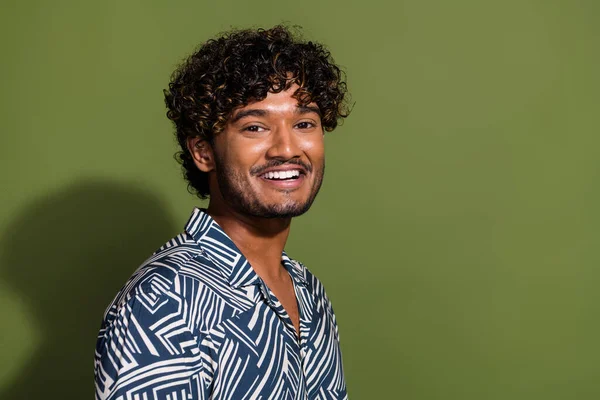 Photo of young optimistic friendly latin curly hair guy in trendy shirt cheerful smiling glad posing isolated on khaki color background.