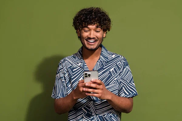 Photo of cheerful positive guy wear print shirt communicating instagram twitter telegram facebook isolated khaki color background.
