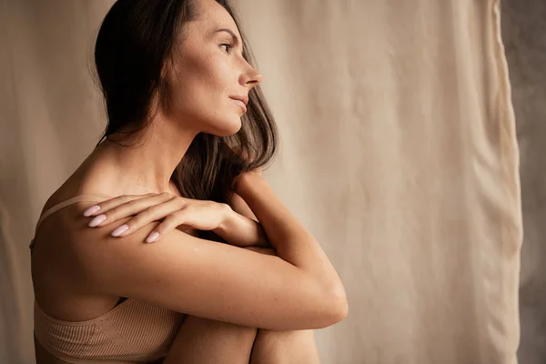 柔らかい夢見る女性の写真 柔らかい皮に触れるレタッチボディ 隔離された自然な日光ベージュのリネンの布の背景 — ストック写真