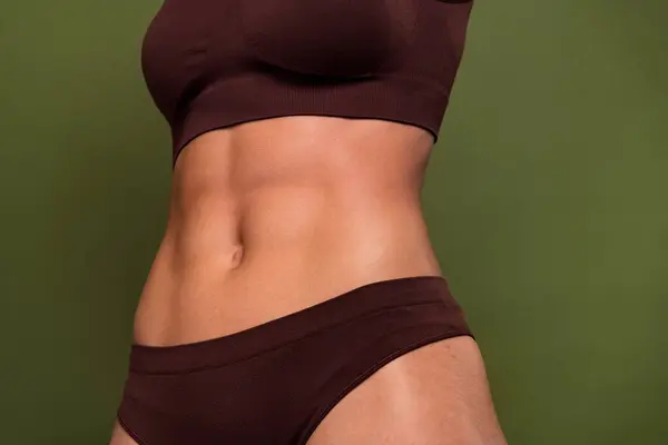 Cropped no retouch photo of amazing ideal figure stomach gym exercises training isolated on khaki color background.