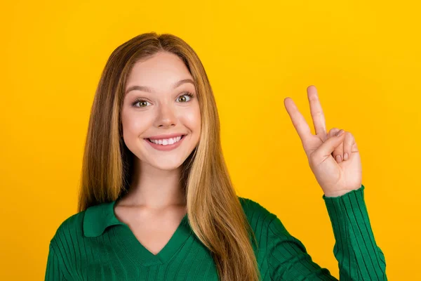 愛らしい肯定的な少女の写真 笑顔の腕の指は黄色の背景で隔離されたV Signを示します — ストック写真