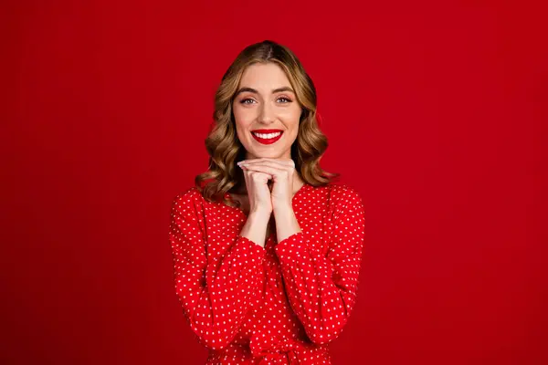 Photo of gorgeous cheerful person toothy smile hands under chin isolated on vibrant red color background.