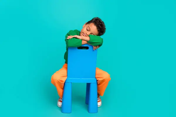Zdjęcie Uroczego Chłopca Noszącego Stylowe Zielone Ubrania Śpiące Wygodne Krzesło — Zdjęcie stockowe