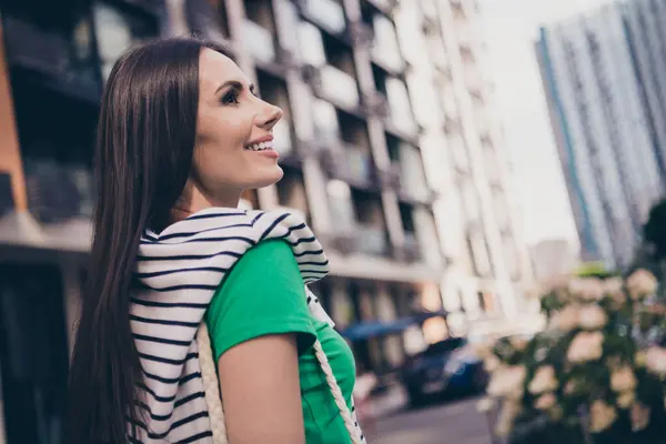 Side profile photo of adorable latin young woman looking side good mood enjoy weekend spending outdoors on residential complex background.