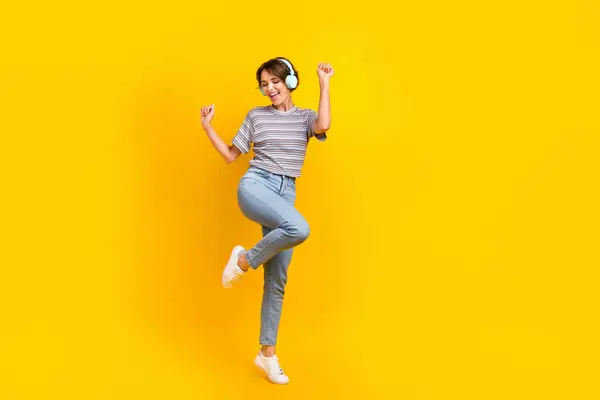 全身上下都是快乐无忧无虑的女士跳舞的照片听音乐耳机空旷的空间隔离在黄色的背景下 — 图库照片