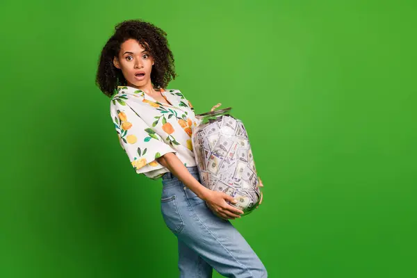 Photo of excited impressed woman dressed print shirt holding heavy money glass jar empty space isolated green color background.