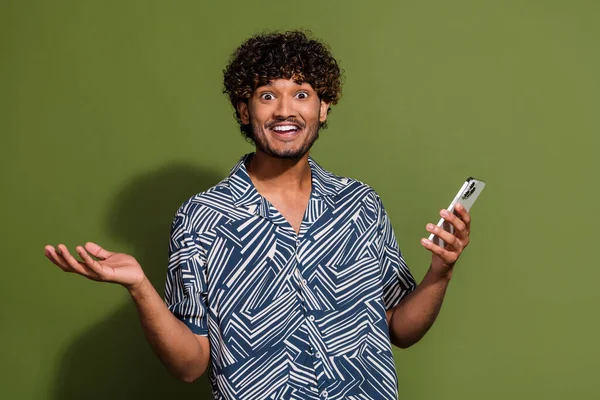 Photo of excited impressed guy wear print shirt texting apple iphone samsung modern device isolated khaki color background.