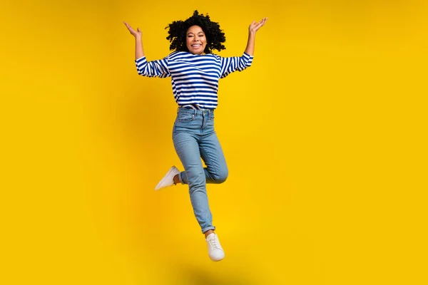 良い気分の女の子の完全な長さの写真は 鮮やかな黄色の背景で孤立した手を上げるストライププオーバージーンズを着用します — ストック写真