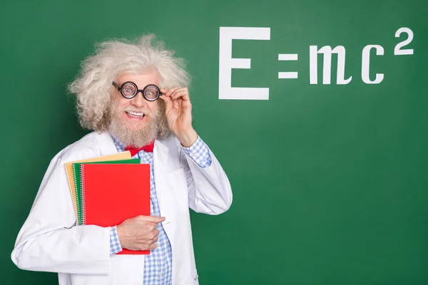 Photo of crazy excited old man hold notebooks college professor wear glasses mathematics isolated on green color background.