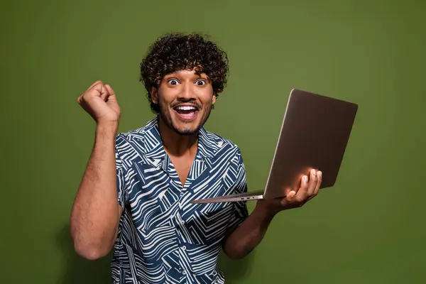 Photo of funky lucky man dressed print shirt winning game modern gadget empty space isolated green color background.