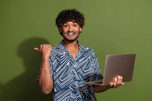 Photo of positive impressed man dressed print shirt texting modern gadget thumb empty space isolated green color background.