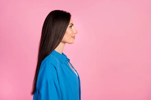 Side profile portrait of girlish woman with long hair wear stylish clothes look at discount empty space isolated on pink color background.