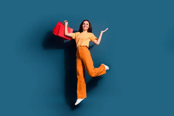 全长照片 买方妇女跳与红包便宜货广告Louis Vuitton品牌与深蓝色背景隔离 — 图库照片