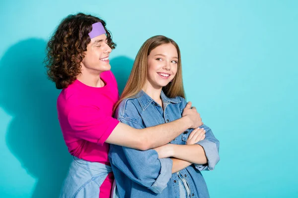 Photo of two young partners couple teenagers hugs wearing hipster outfit smiling after conflict solved isolated on blue color background.
