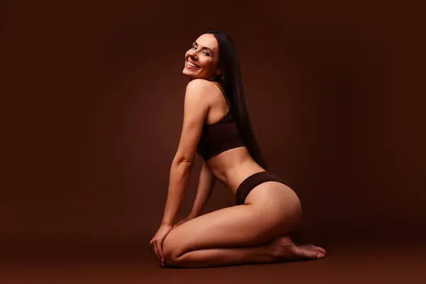 Full size photo no retouch of attractive woman against body shaming sit floor dressed stylish underwear isolated on brown color background.