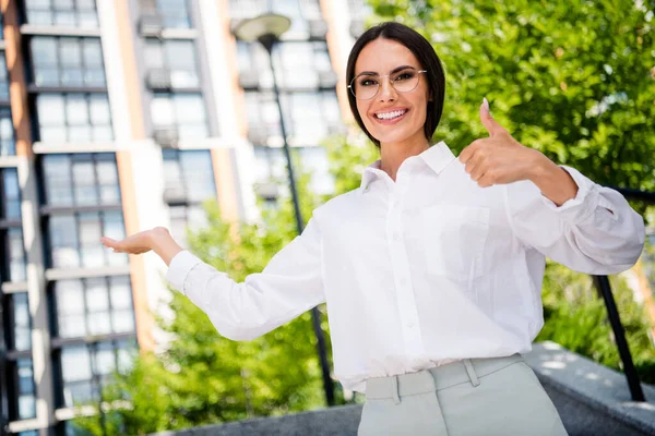 Photo of successful gorgeous lady in park dressed stylish white shirt glasses recommend buy rent comfort real estate dwelling city center.