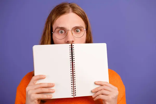 Close up photo of funny nerd student guy shocked realizing read his planner forgot about exam tomorrow isolated on violet color background.