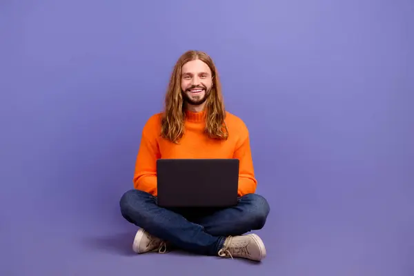 Full body size photo of young blond long hair man wear sweater like new trend to work in sitting pose isolated on purple color background.