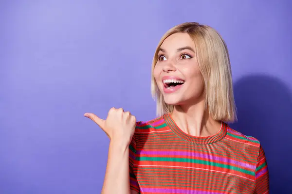 Portrait of young astonished lady bob blonde hair model wear knitted orange t shirt point finger novelty isolated on violet color background.