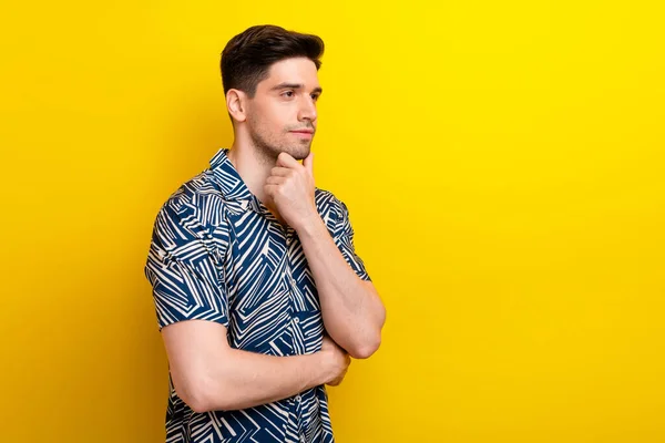 Photo of pensive puzzled man with stylish hairdo dressed blue clothes look at offer emppty space isolated on yellow color background.