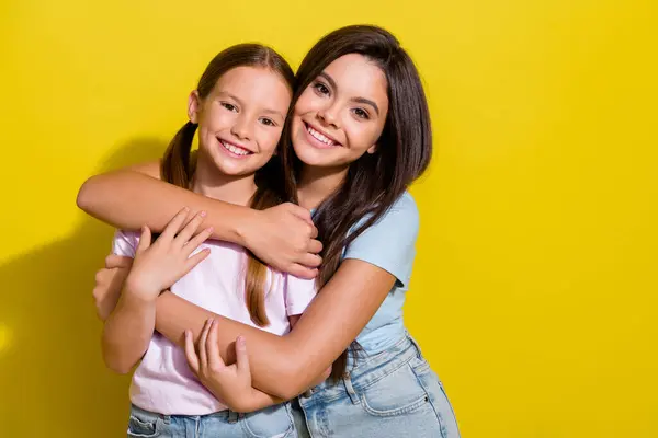 かなり陽気な小さな姉妹の写真は 単離された黄色の背景を微笑むTシャツを着ています — ストック写真