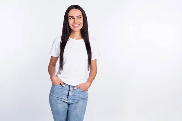 白い色の背景に隔離された空白のスペースを見ている白いTシャツのジーンズを身に着けている女性の写真の肖像画 — ストック写真