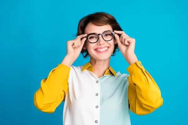 年轻快乐的办公室经理试戴她的新眼镜的画像 看上去像一个蓝色背景的聪明的极客 — 图库照片