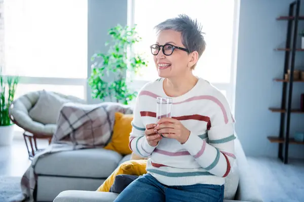 Photo of adorable excited lady wear striped pullover spectacles enjoying fresh water indoors room home house.