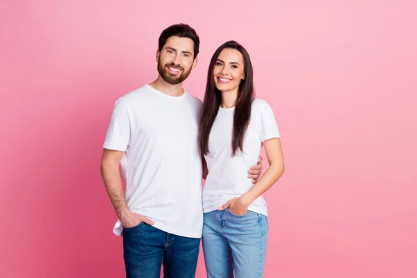 魅力的な若いカップルの写真の肖像画は モデルを抱擁し ピンク色の背景に隔離されたトレンディな白い服を着ています — ストック写真