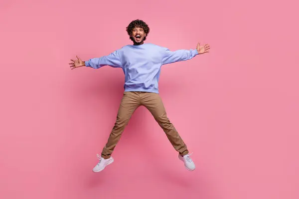 陽気なファンキーな幸せな男性の写真は 青いトレンディな服を着用して ピンク色の背景に隔離された祝賀旅行休暇をジャンプします — ストック写真