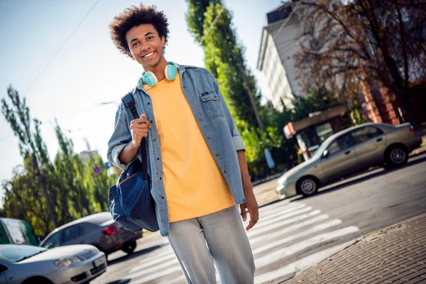 面白い興奮した男の写真 デニムジャケットイヤホンを着用 都市街の外の道路のゼブラを渡る — ストック写真