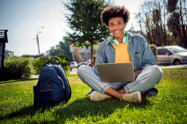 Stock image Photo of cheerful positive guy wear denim jacket earphones chatting instagram twitter telegram facebook outside urban city street.