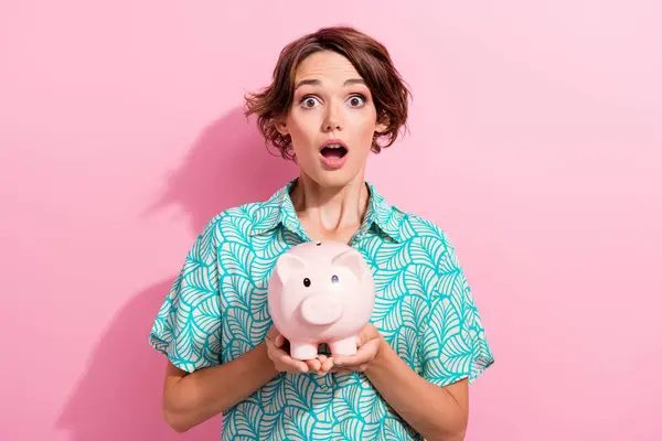 Photo of speechless confused person open mouth arms hold money savings bank pig isolated on pink color background.