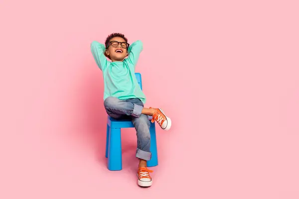 ピンク色の背景に隔離されたトレンディなアクアマリン衣服を着用する愛らしい小さな男の子の椅子の完全な長さの写真 — ストック写真