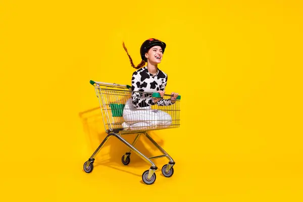 stock image Full size profile portrait of overjoyed girl inside market pushcart ride empty space isolated on yellow color background.