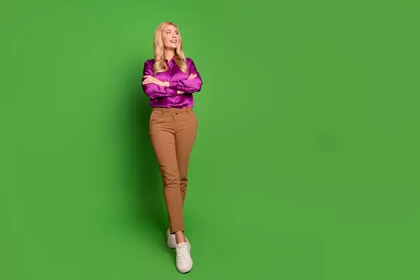 全长的照片 体贴入微的漂亮女人 身穿紫色衬衫 双臂交叉 相望空旷的空间 孤零零的绿色背景 — 图库照片