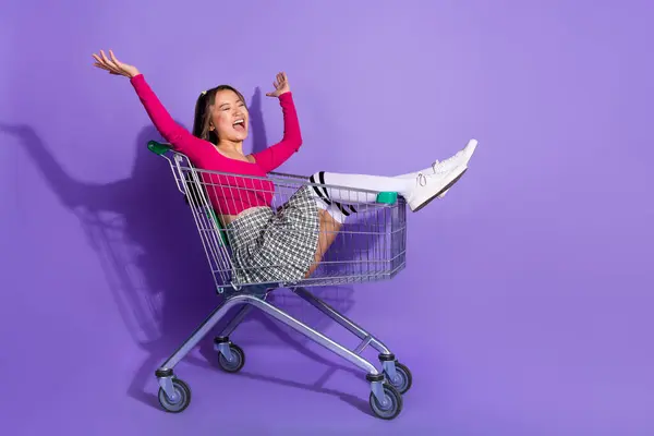 全长照片 兴奋的女士身穿顶部上升的手骑超市推车空旷的空间孤立的紫罗兰背景 — 图库照片