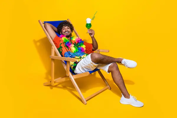 全长的照片 穿着哈威衬衫 喝着绿色鸡尾酒 坐在椅子上度假 与黄色背景隔离 — 图库照片