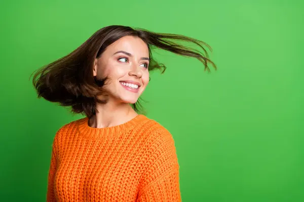 Portrait of lovely cheerful person flying hair toothy smile look empty space isolated on green color background.