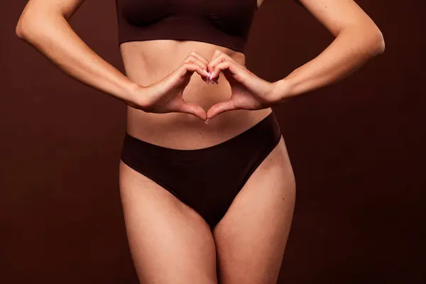 Cropped photo no filter of pretty young girl heart gesture body positive dressed stylish underwear isolated on brown color background.
